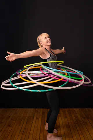 Hula Hoop artist Judi Jones is balancing and circling a dozen hula hoops at the same time. 