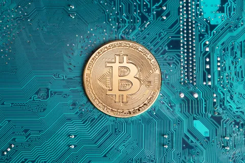 A B on a gold coin with a background that is green. 