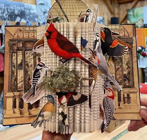 An image of an altered book from the Florence Griswold Museum with birds on it.